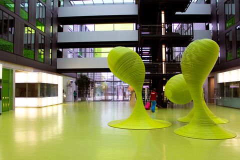 Blick vom APB Foyer Richtung Eingang, im Vordergrund sind die ikonischen grünen Stahlskulpturen zu sehen.